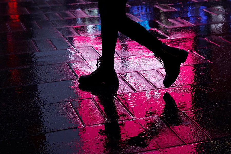 Una mujer aparece en una fotografía de archivo caminando por Times Square durante la noche en la ciudad de Nueva York.